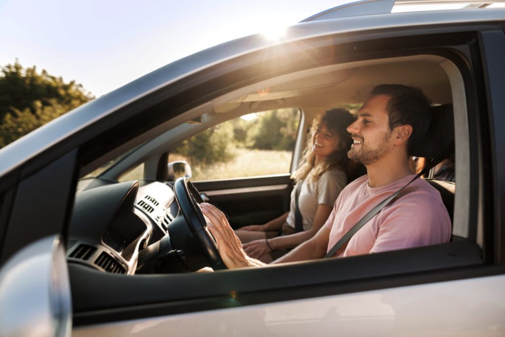 A photo of a man and a woman driving in a car.